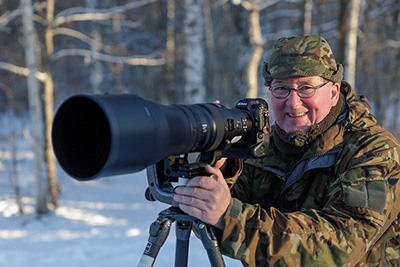 Jan fotograferar med ett Nikon teleobjektiv.